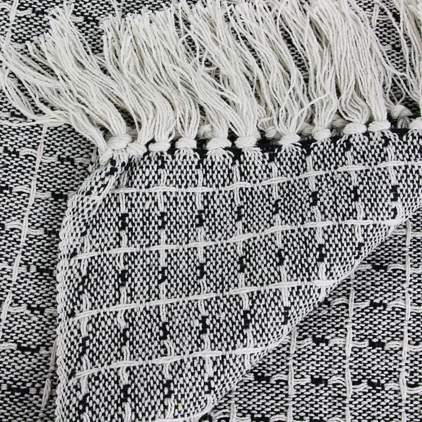 Détail du motif pointillé sur plaid ethnique artisanal, texture douce et authentique