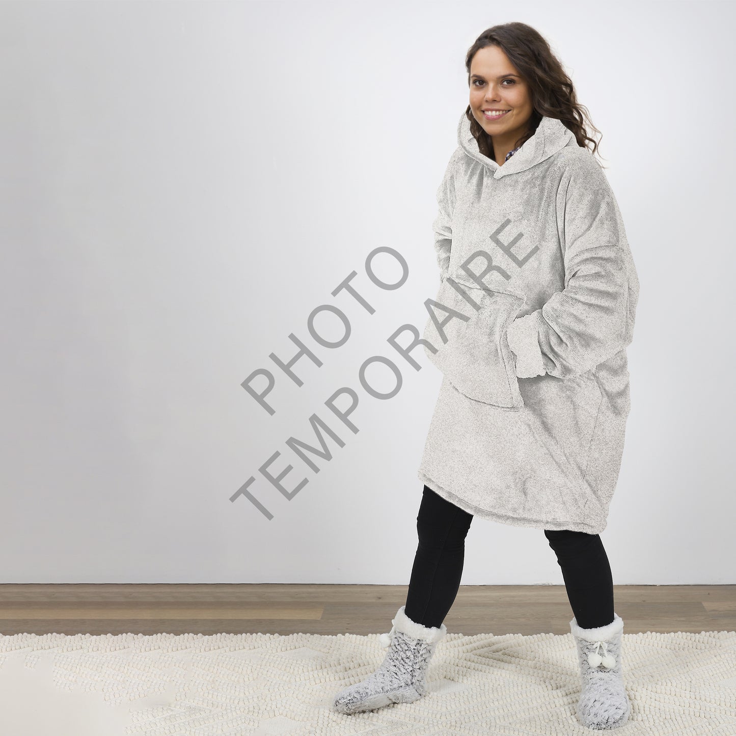 Personne portant le plaid poncho gris ZenPur dans un cadre cosy et décontracté