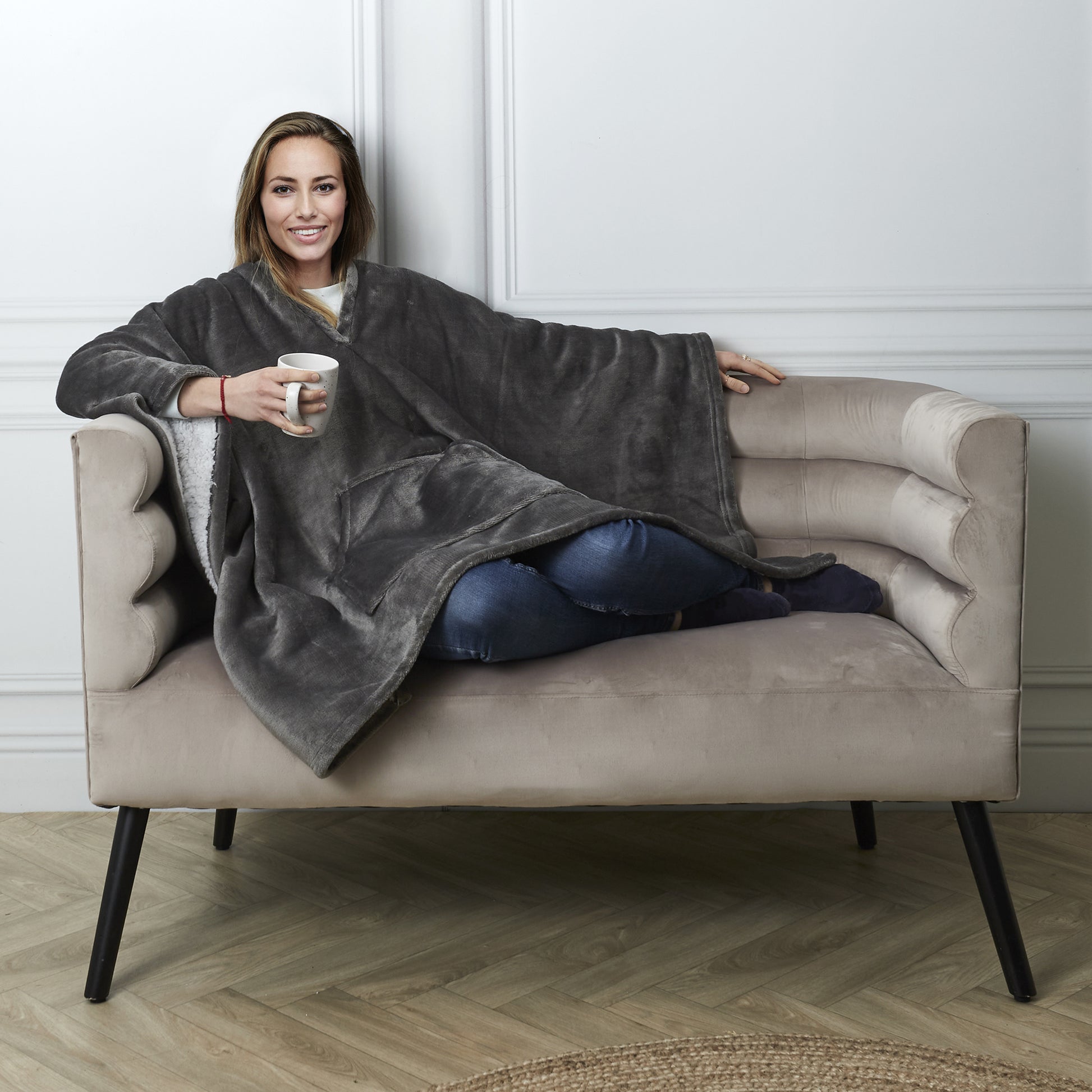 Personne portant le plaid poncho gris ZenPur dans un cadre cosy et décontracté