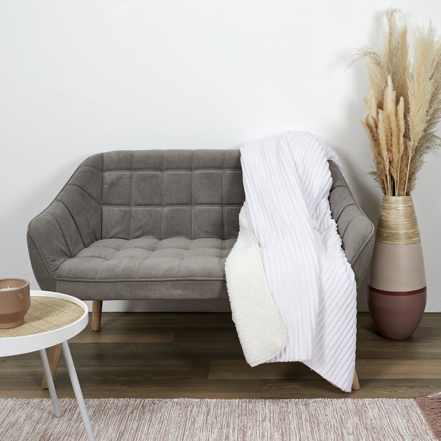 Plaid ZenPur en flanelle côtelée et Sherpa écru posé sur un canapé moderne pour confort et décoration