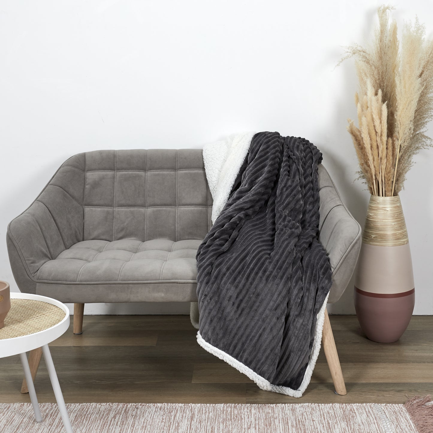 Plaid ZenPur en flanelle côtelée et Sherpa posé sur un canapé moderne pour confort et décoration