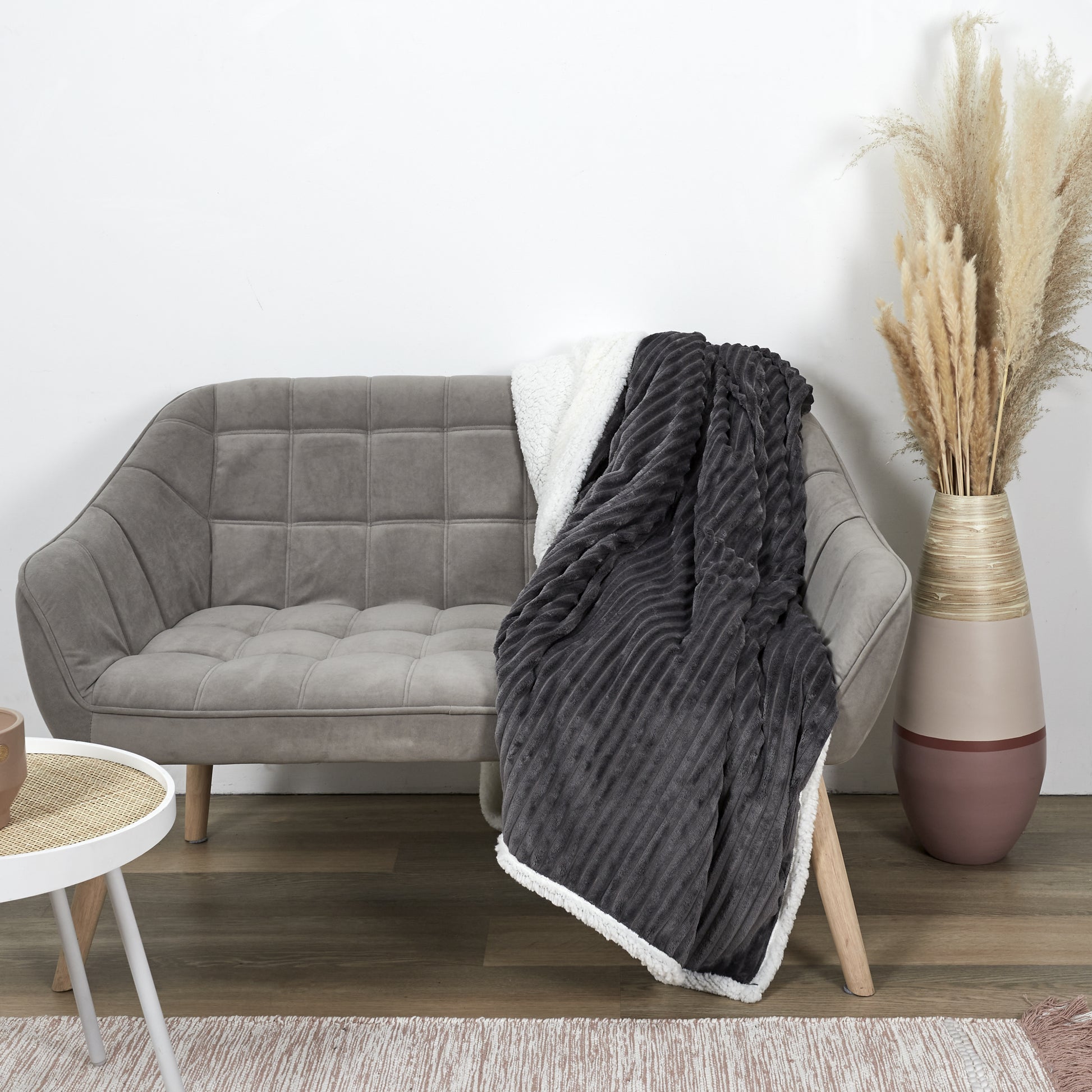 Plaid ZenPur en flanelle côtelée et Sherpa posé sur un canapé moderne pour confort et décoration