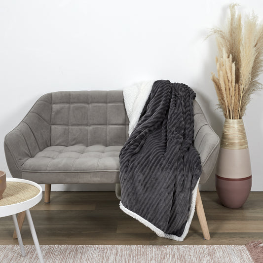 Plaid ZenPur en flanelle côtelée et Sherpa posé sur un canapé moderne pour confort et décoration