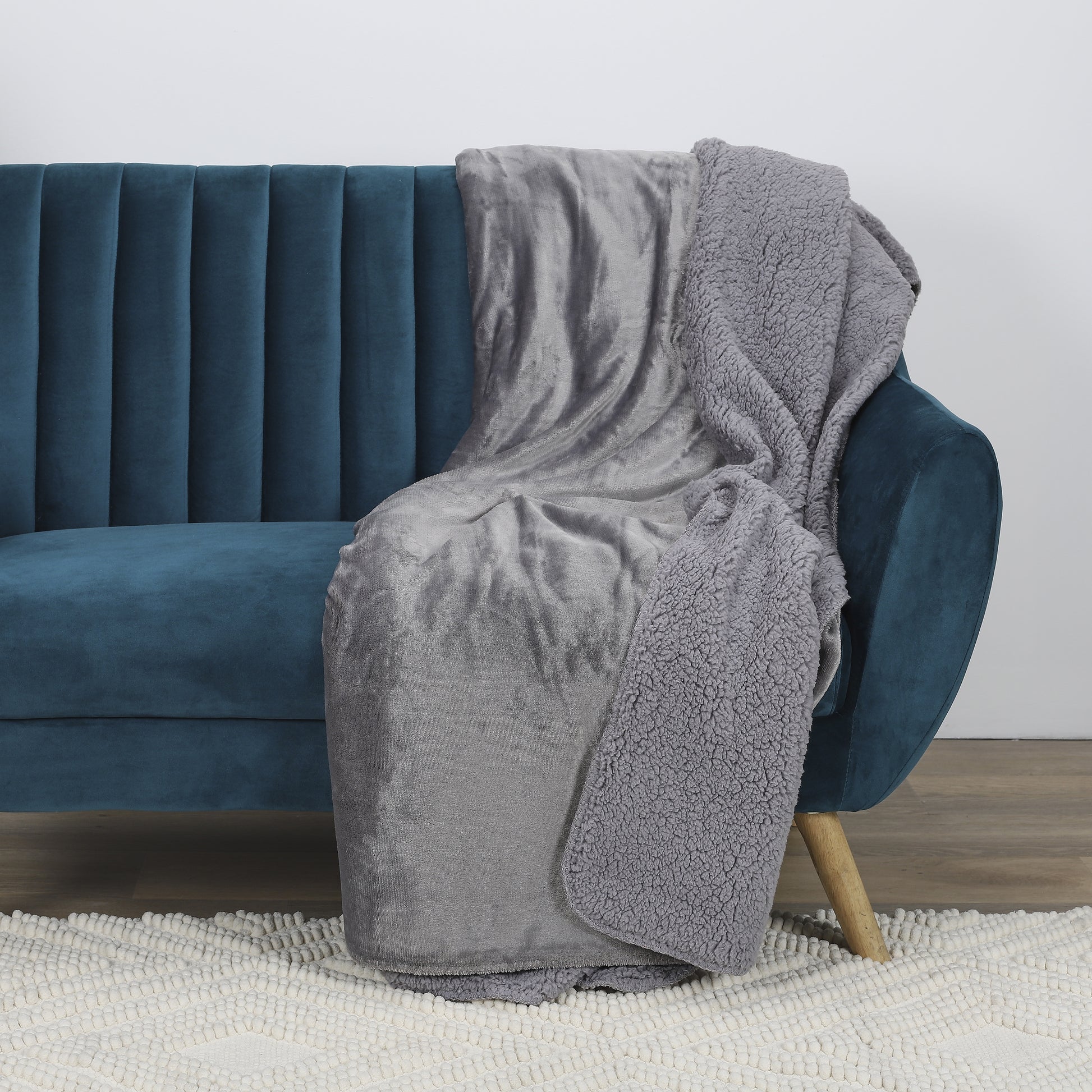 Plaid doux en flanelle et Sherpa gris élégant ZenPur posé sur un canapé, couverture cosy pour détente et décoration