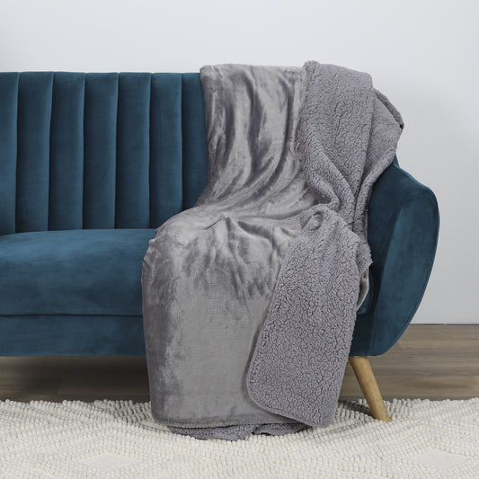 Plaid doux en flanelle et Sherpa gris élégant ZenPur posé sur un canapé, couverture cosy pour détente et décoration
