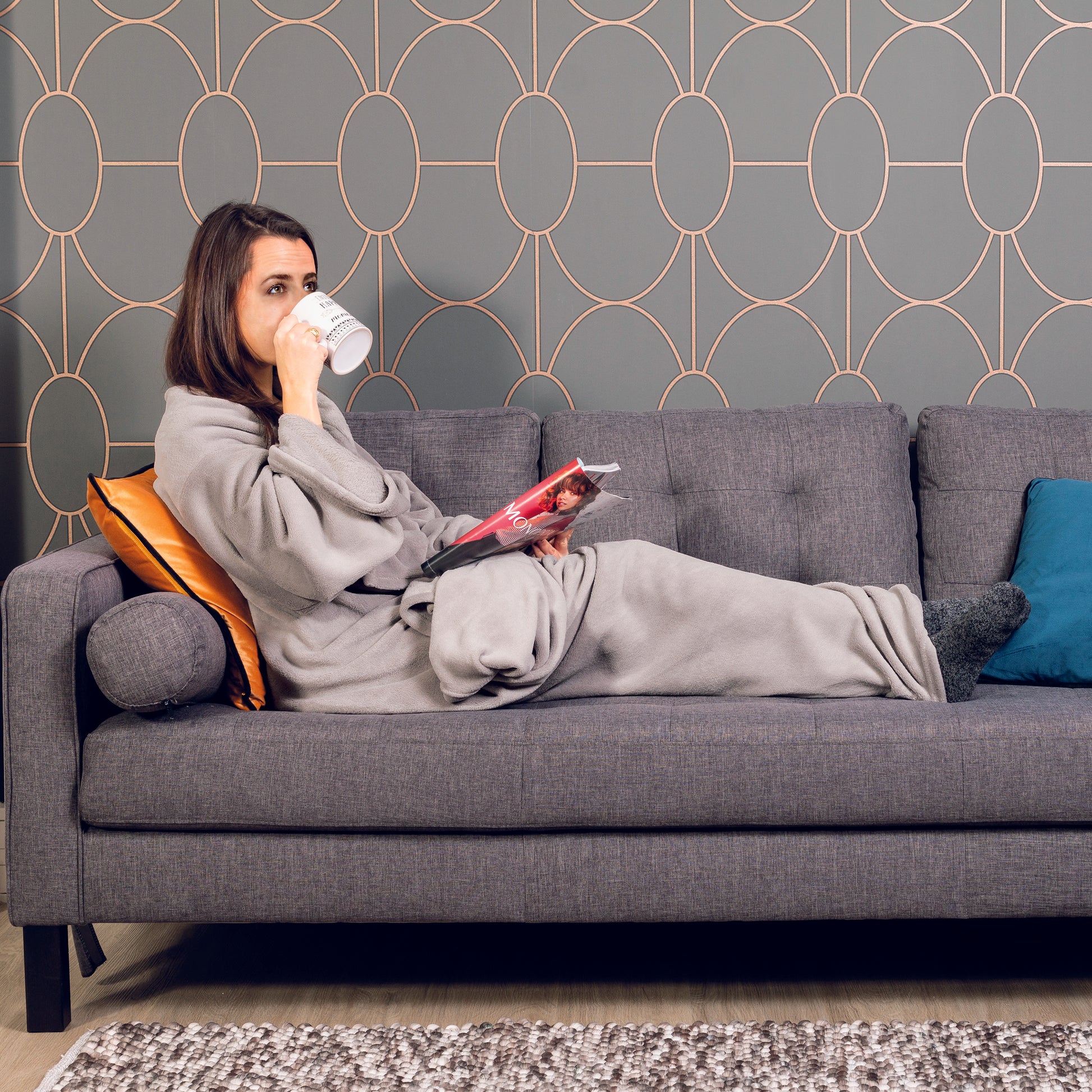 Plaid gris à manches porté par une fille, confort maximal pour lecture, télé ou relaxation