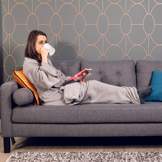 Plaid gris à manches porté par une fille, confort maximal pour lecture, télé ou relaxation
