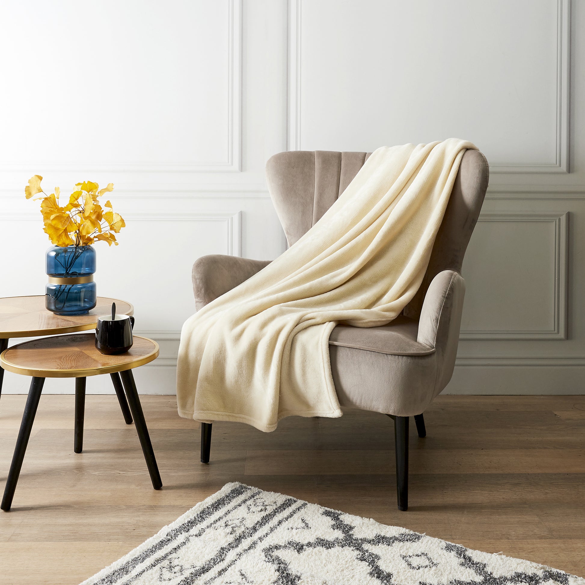 Plaid pochon en flanelle écru ZenPur posé sur une chaise ou fauteuil, couverture douce et cosy pour détente